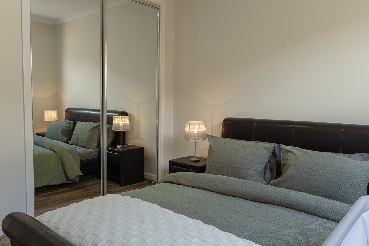 Soft lamp light and layered bedding give this bedroom a warm, restful feel for settling in at Willows Stays Holiday.