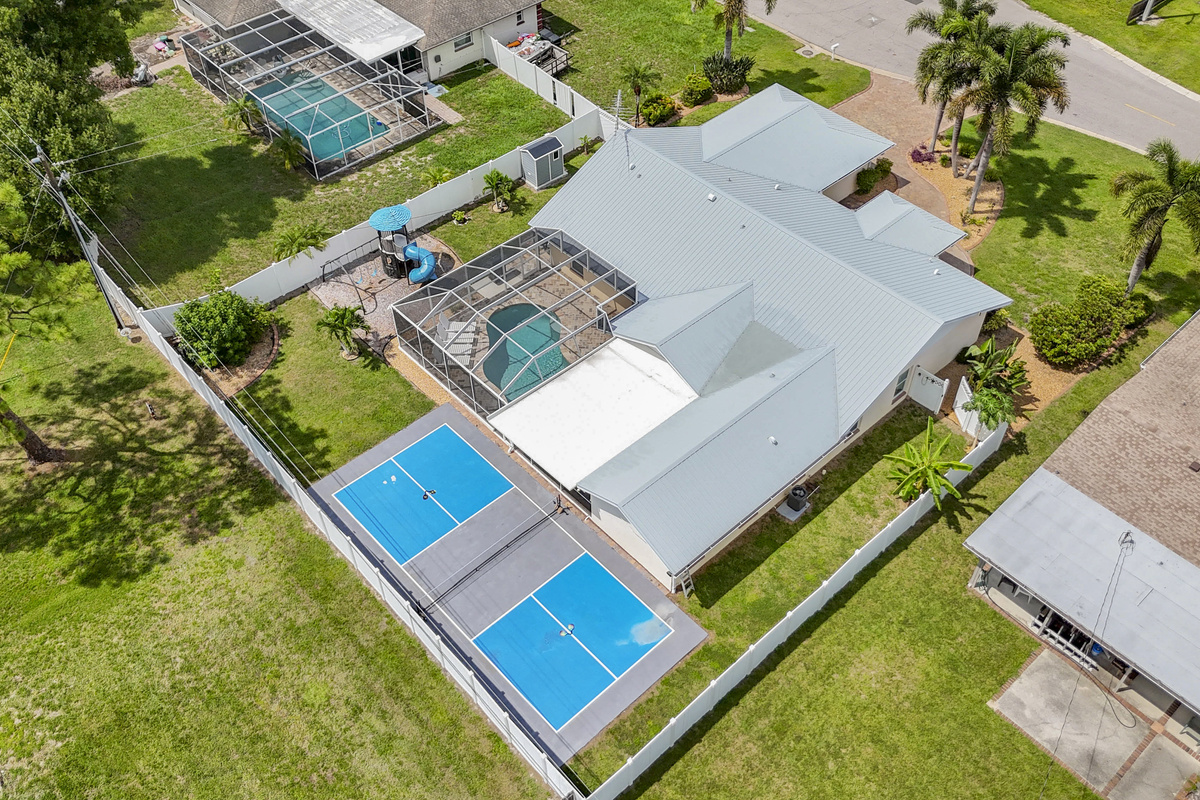 Take in the full picture of your private getaway — a stunning aerial view showcasing the sparkling pool, fun-filled playset, and pickleball court, all surrounding your beautiful vacation home. The ultimate family retreat awaits!