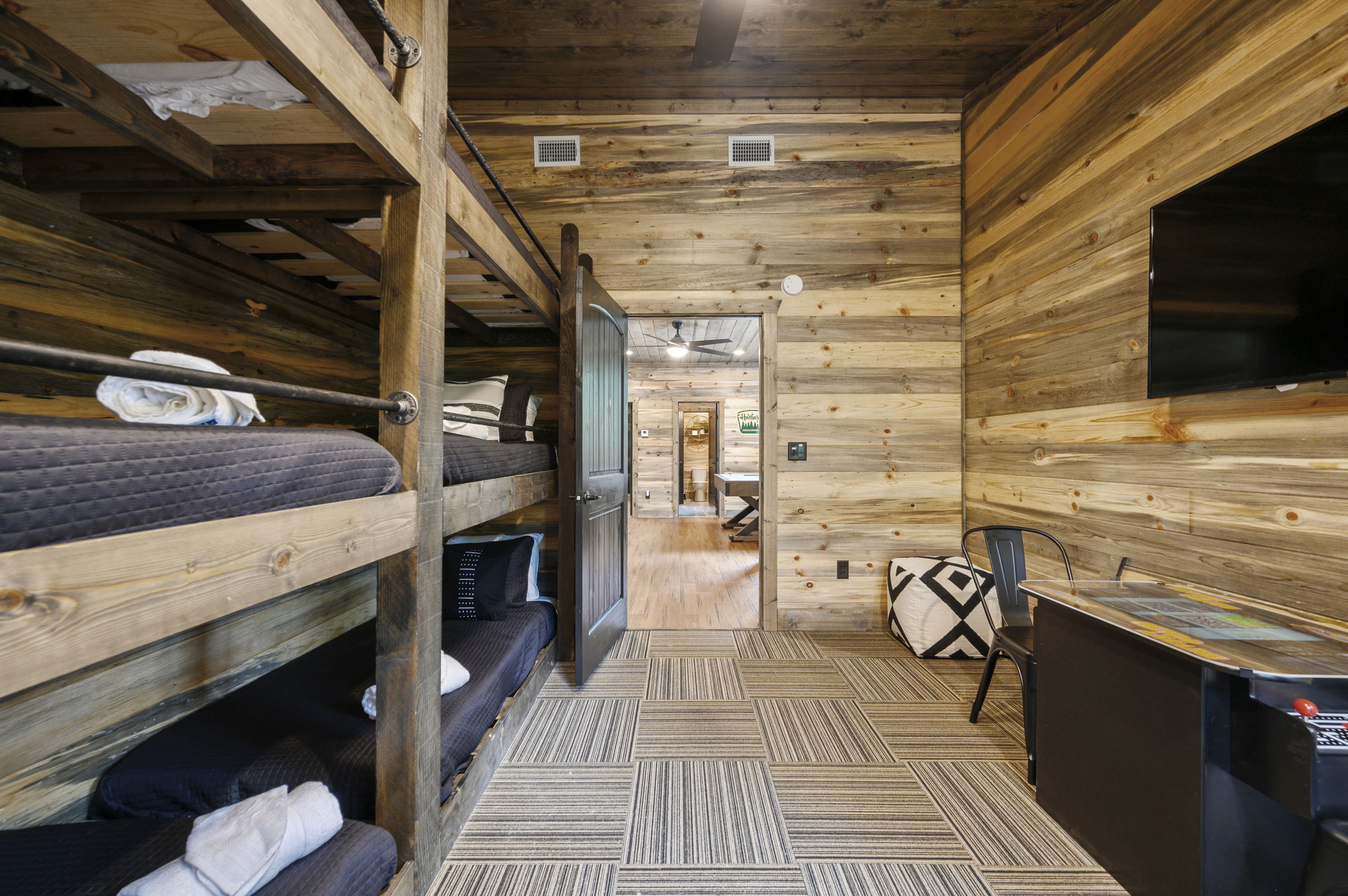 The ultimate kids’ bunkroom! Two triple bunks with six twin beds, a retro arcade game, and a Smart TV, with the game room just outside the door. Perfect for cousins, siblings, and late-night sleepover fun.