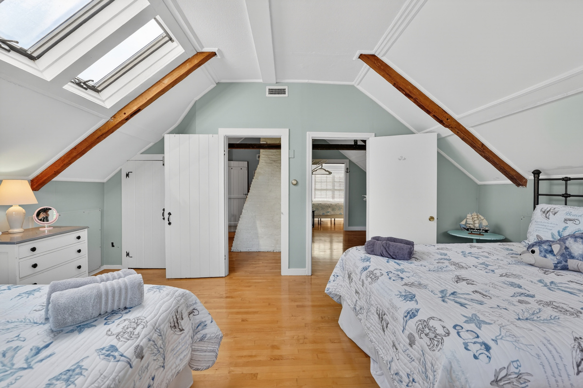 Open loft-style sleeping area with vaulted ceilings, skylights, and plenty of room for everyone to relax.