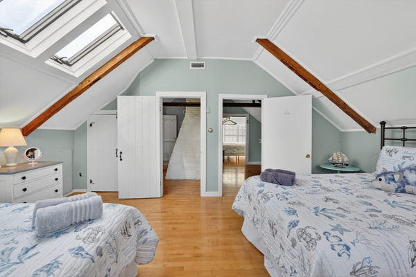 Open loft-style sleeping area with vaulted ceilings, skylights, and plenty of room for everyone to relax.