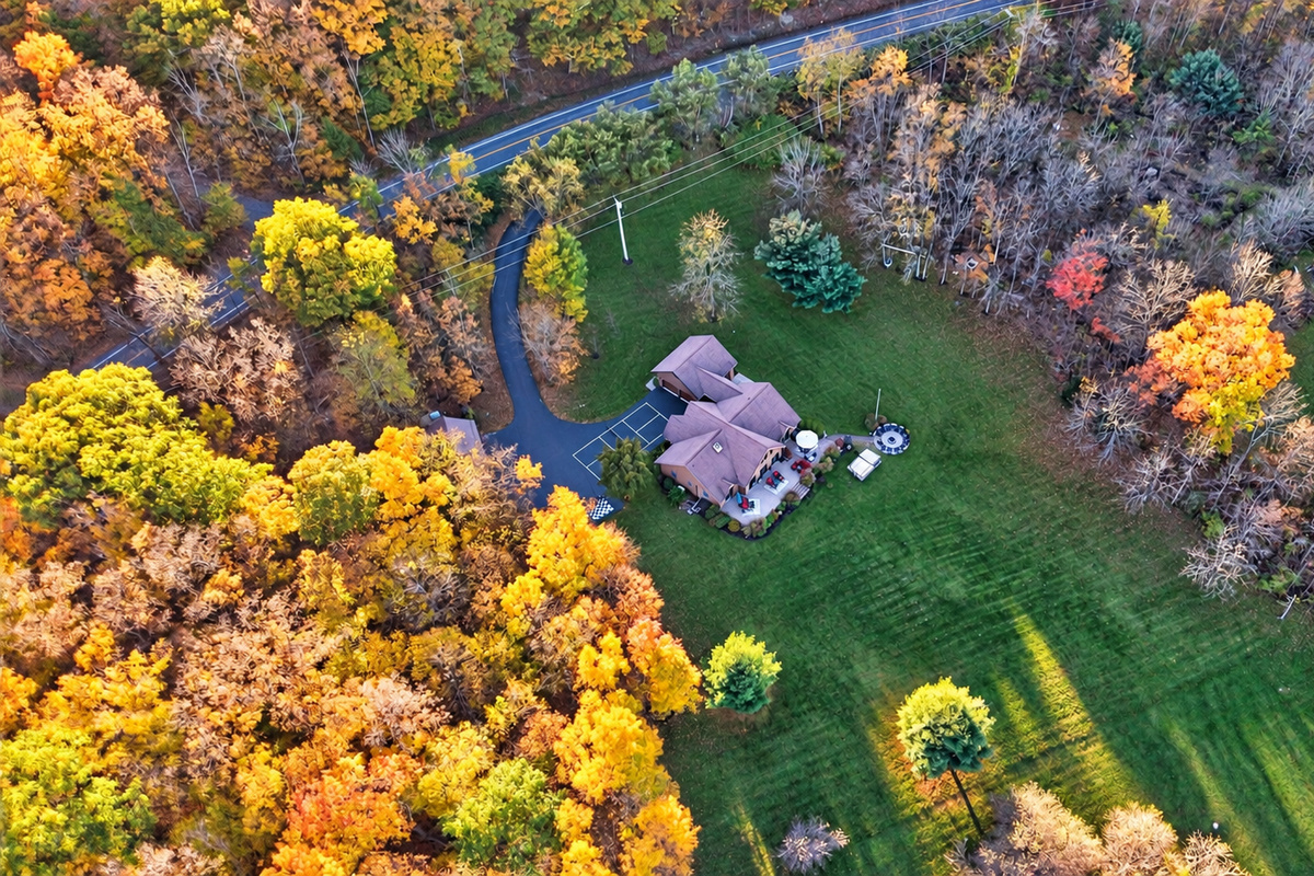 Expansive lawn surrounded by colorful autumn woodland