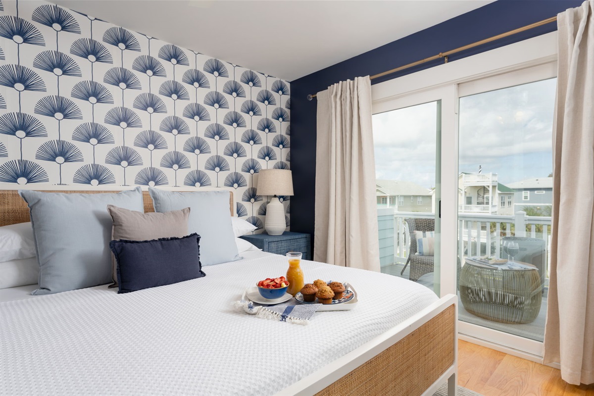 Third-floor king suite with sliding doors to a private balcony overlooking the neighborhood.