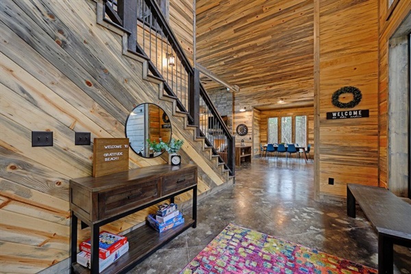 A breathtaking cabin interior with rustic modern design, polished concrete floors, and stylish wood accents creates a welcoming atmosphere. Board games and warm decor make this a family-friendly vacation rental, ideal for a cozy getaway.