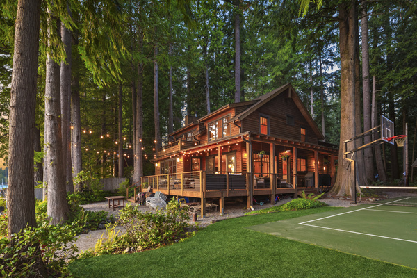 Side view of the house and sports court, surrounded by the peaceful privacy and serene natural beauty of the area.