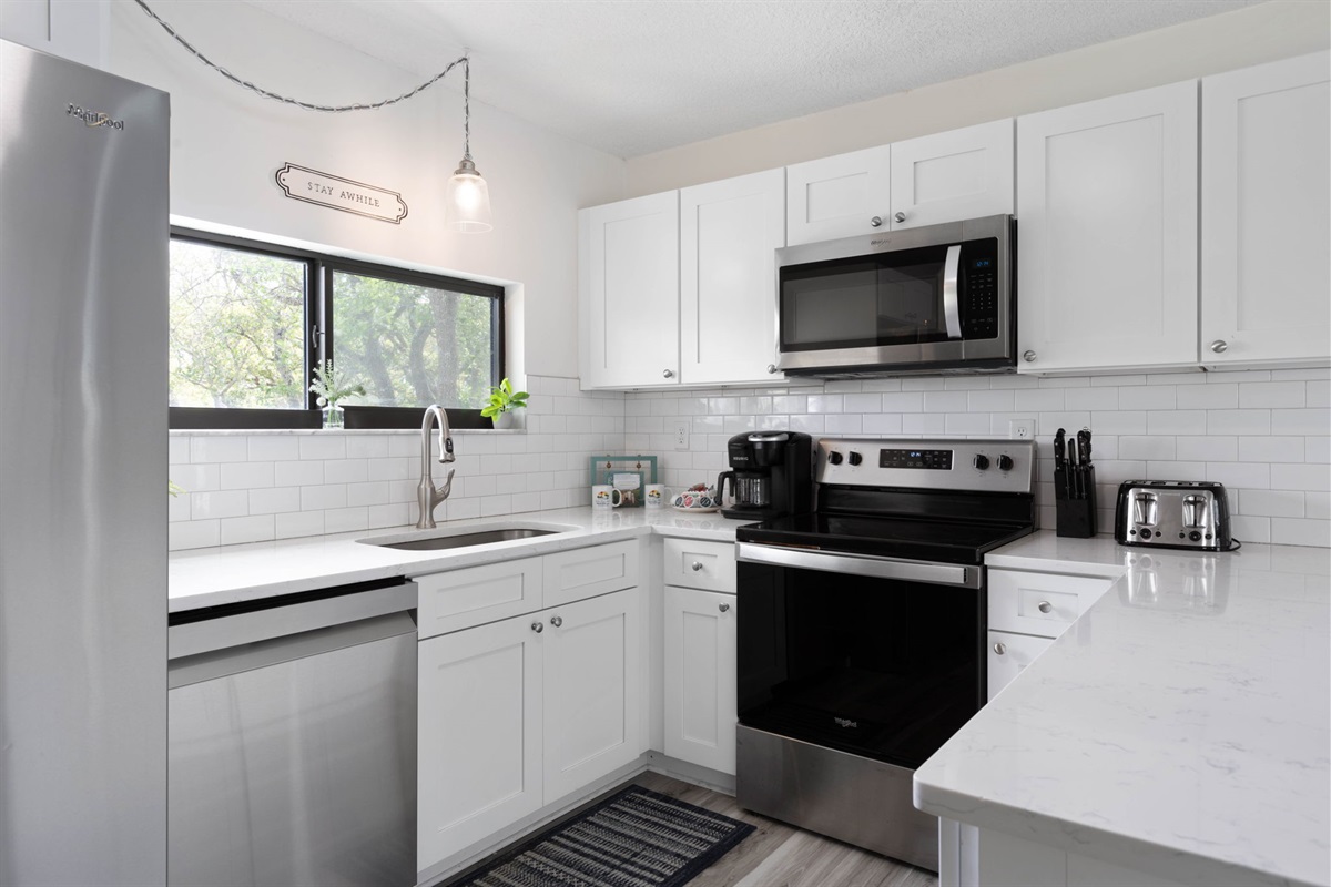 In this bright, polished kitchen, mornings begin with pancakes on the stove, coffee brewing, and sunlight slipping through the window. It is where sleepy conversations turn into family plans for the beach, and simple breakfasts become part of the memory.