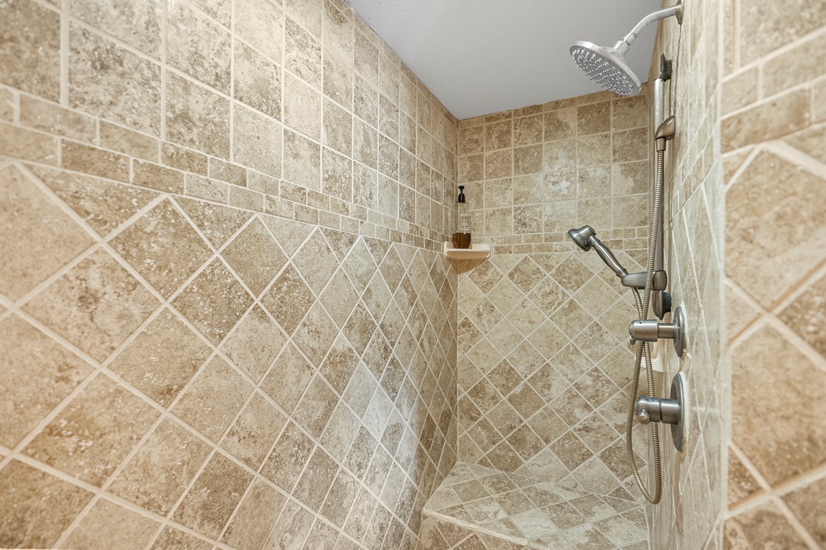 Walk-in shower with bench seating and upgraded tile finishes.