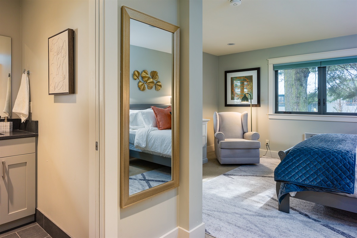 The second primary bedroom features a warm amount of natural light and the perfect chair for reading your favorite book. 