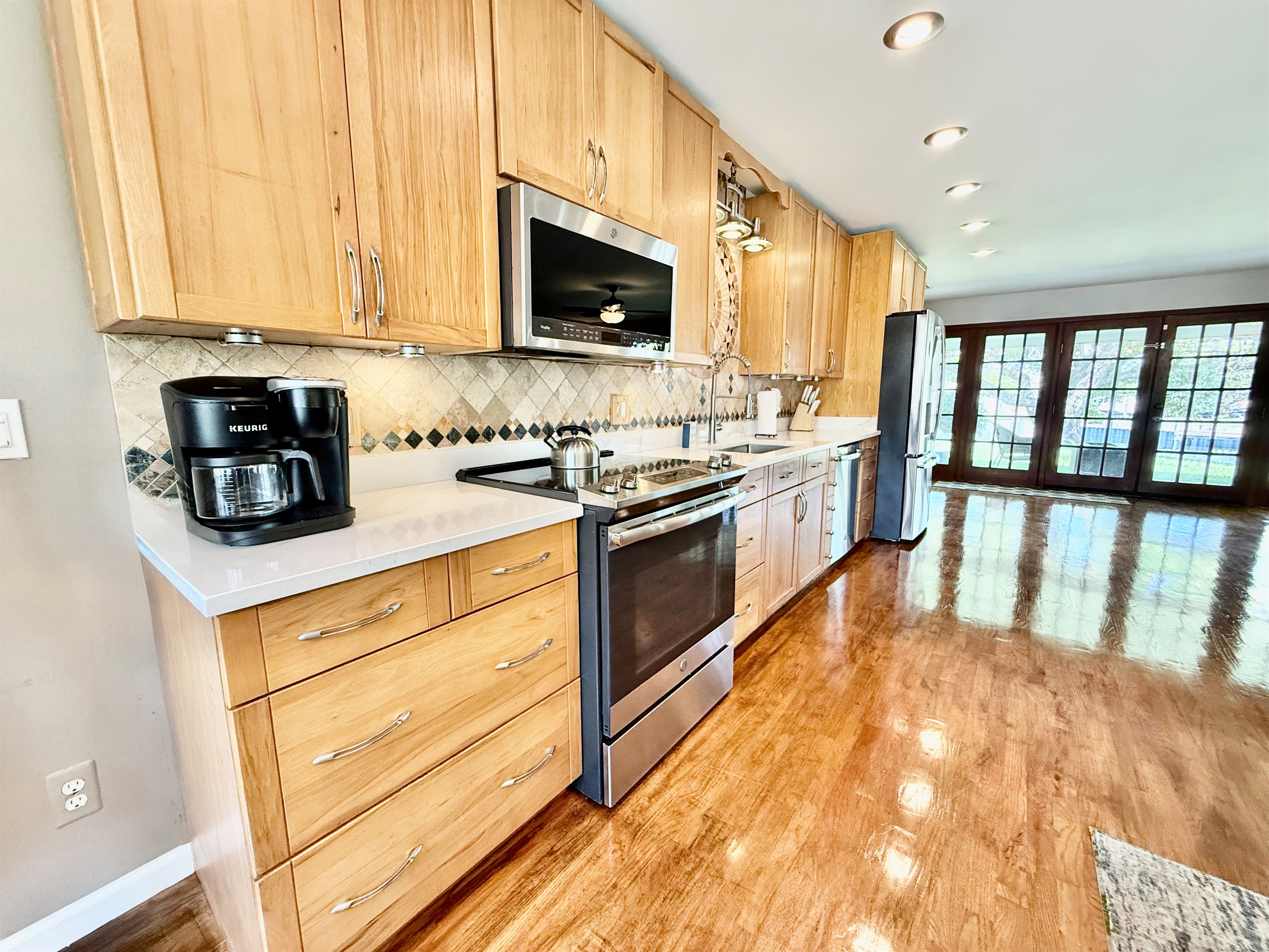 This gorgeous kitchen features stainless steel appliances, custom wood cabinetry, and a beautiful mosaic backsplash—perfect for whipping up anything from a quick breakfast to a gourmet dinner.