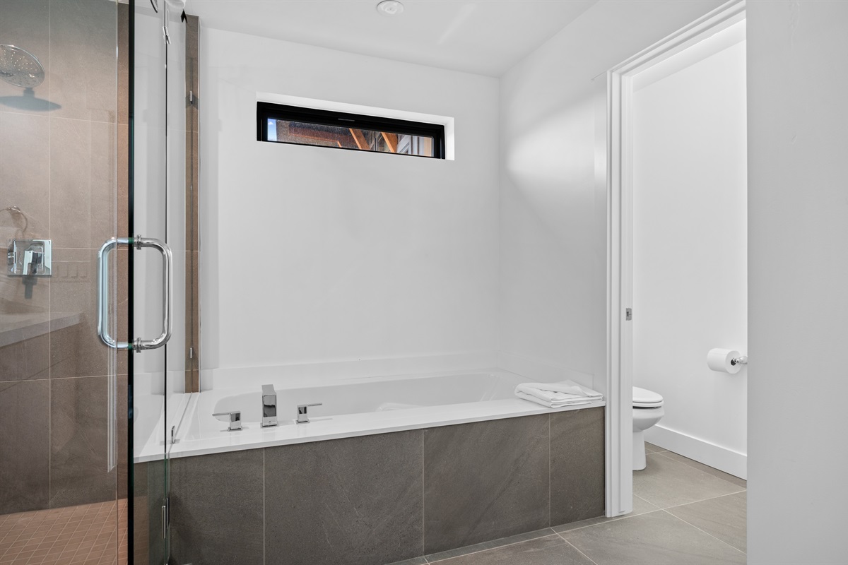 Spa-inspired soaking tub and separate glass shower for ultimate relaxation.
