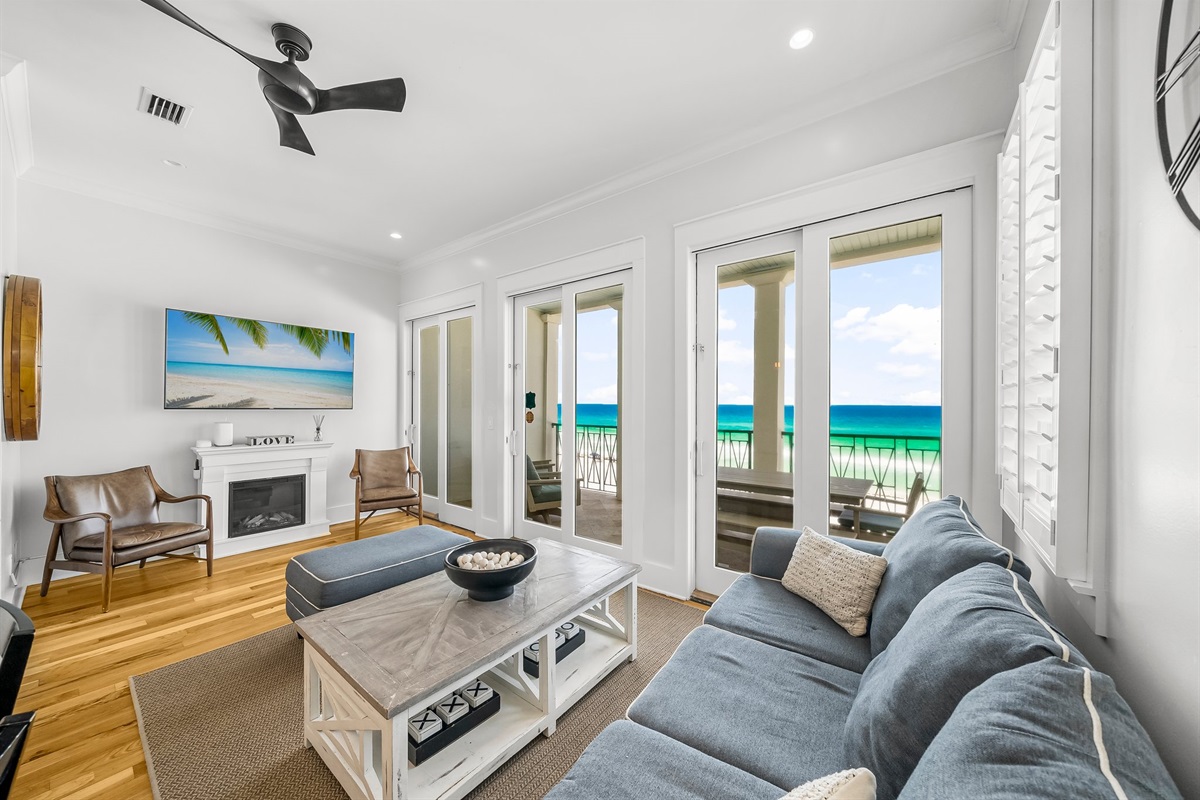 Living Room with comfortable seating, Gulf views, electric fireplace, and 55” Smart TV