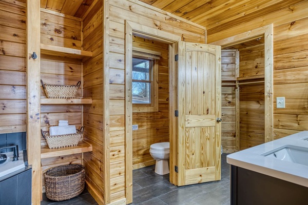 Main-level master bathroom includes double sinks, walk-in shower, jetted tub, separate toilet room, and walk-in closet.