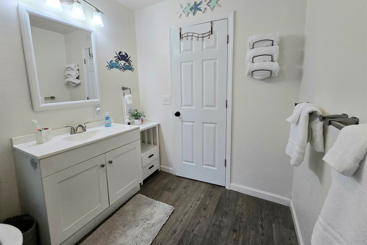 The bathroom is spacious with a bathtub and room to move.