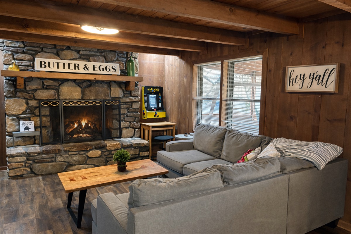 Warm wood interiors, a glowing stone fireplace, and a retro arcade—your perfect mountain cabin evening starts right here.