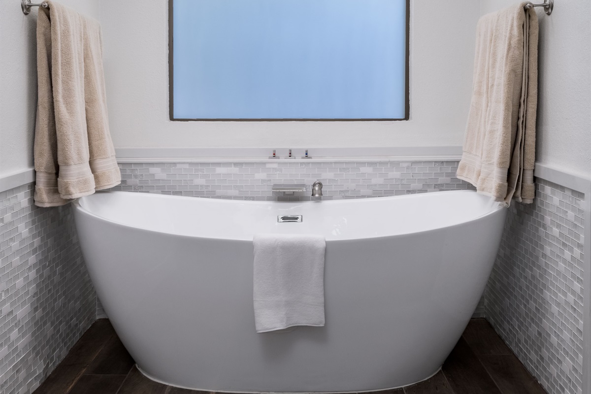 Treat yourself to spa-like luxury with a freestanding soaking tub, double vanities, and a serene modern design made for relaxation.