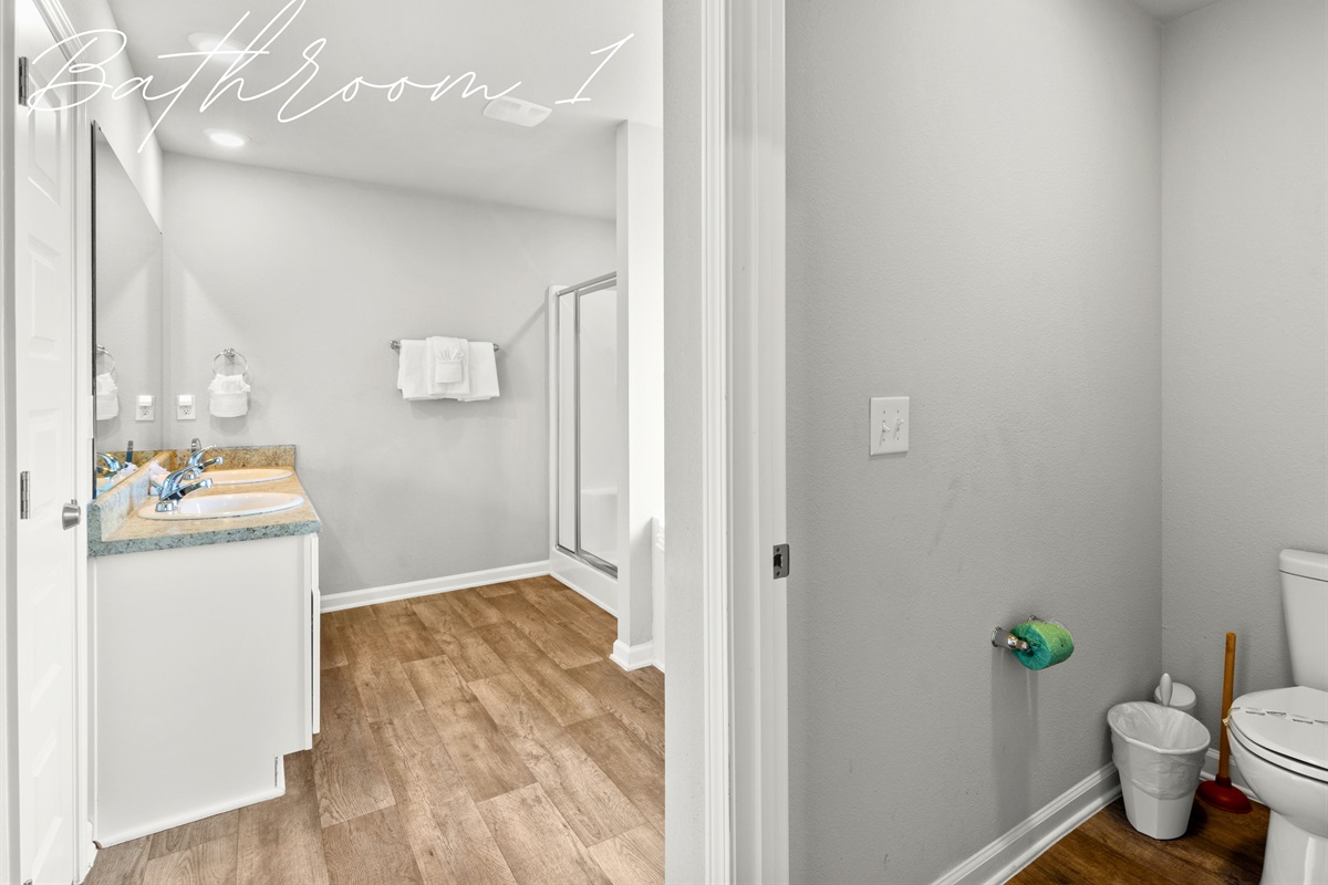 Bathroom 1 offers fresh finishes, plenty of counter space, and a spacious walk-in shower.