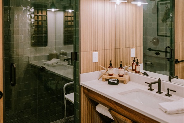 The Homestead Suite's ADA-accessible bathroom &mdash; roll-in shower with grab bars, accessible vanity, and modern Western finishes. Step-free design for every guest in your group.