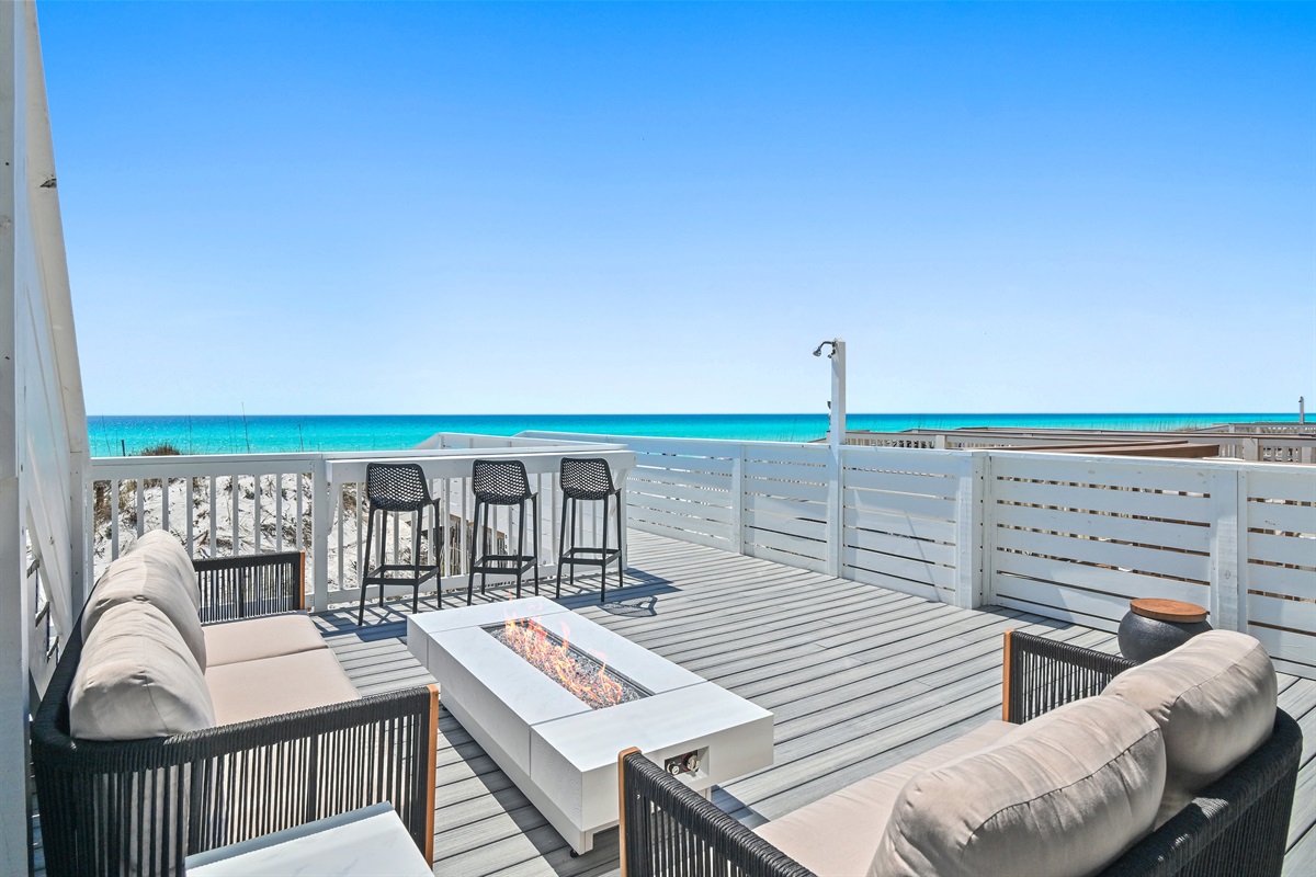 Green Reef 1 first floor patio features an Outdoor Bar with Smart TV, Sauna, Enclosed Shower, Fire Pit, Dining Space, and Shade.