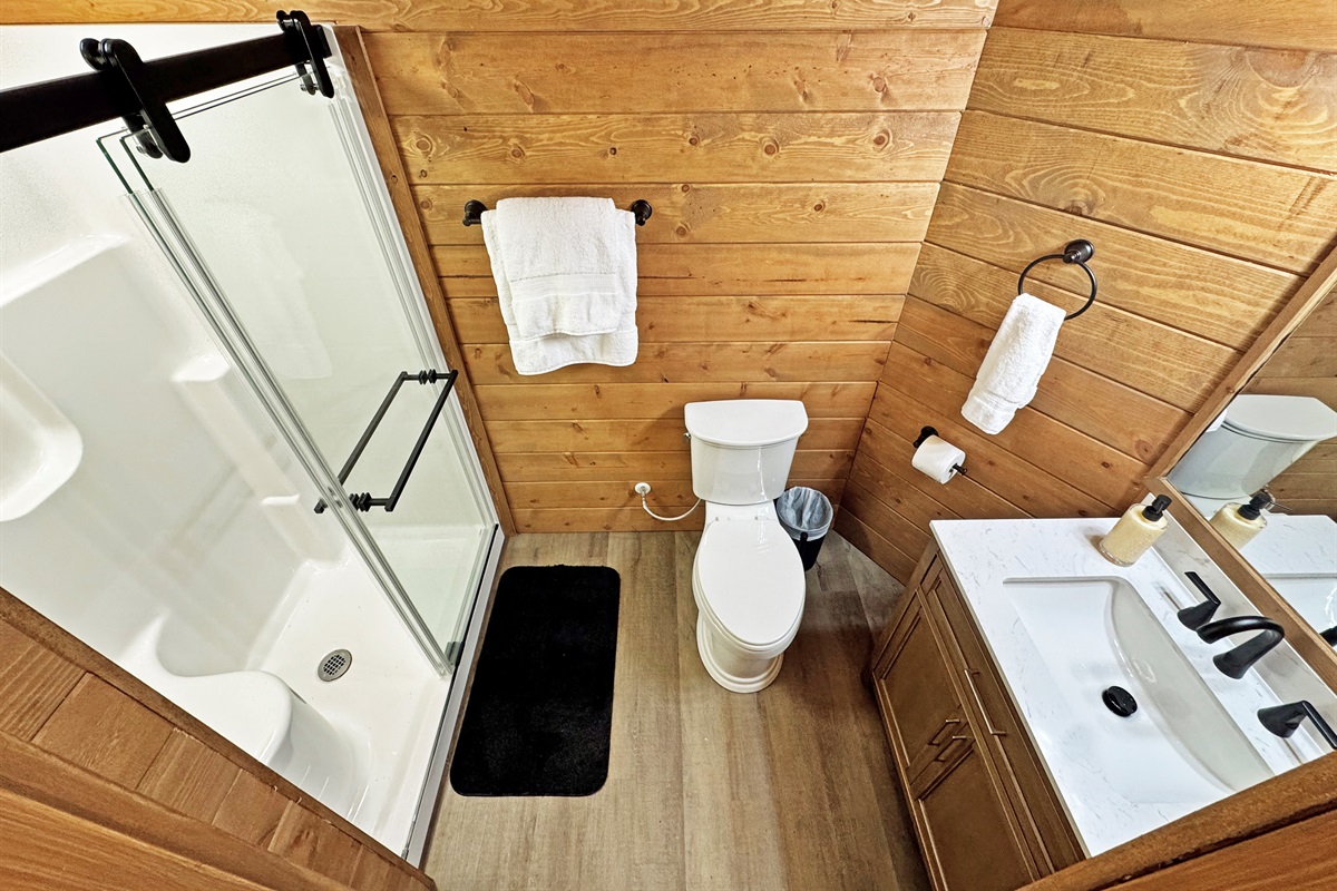 Bathroom Oasis: Enjoy modern elegance with natural wood accents and a refreshing shower experience!