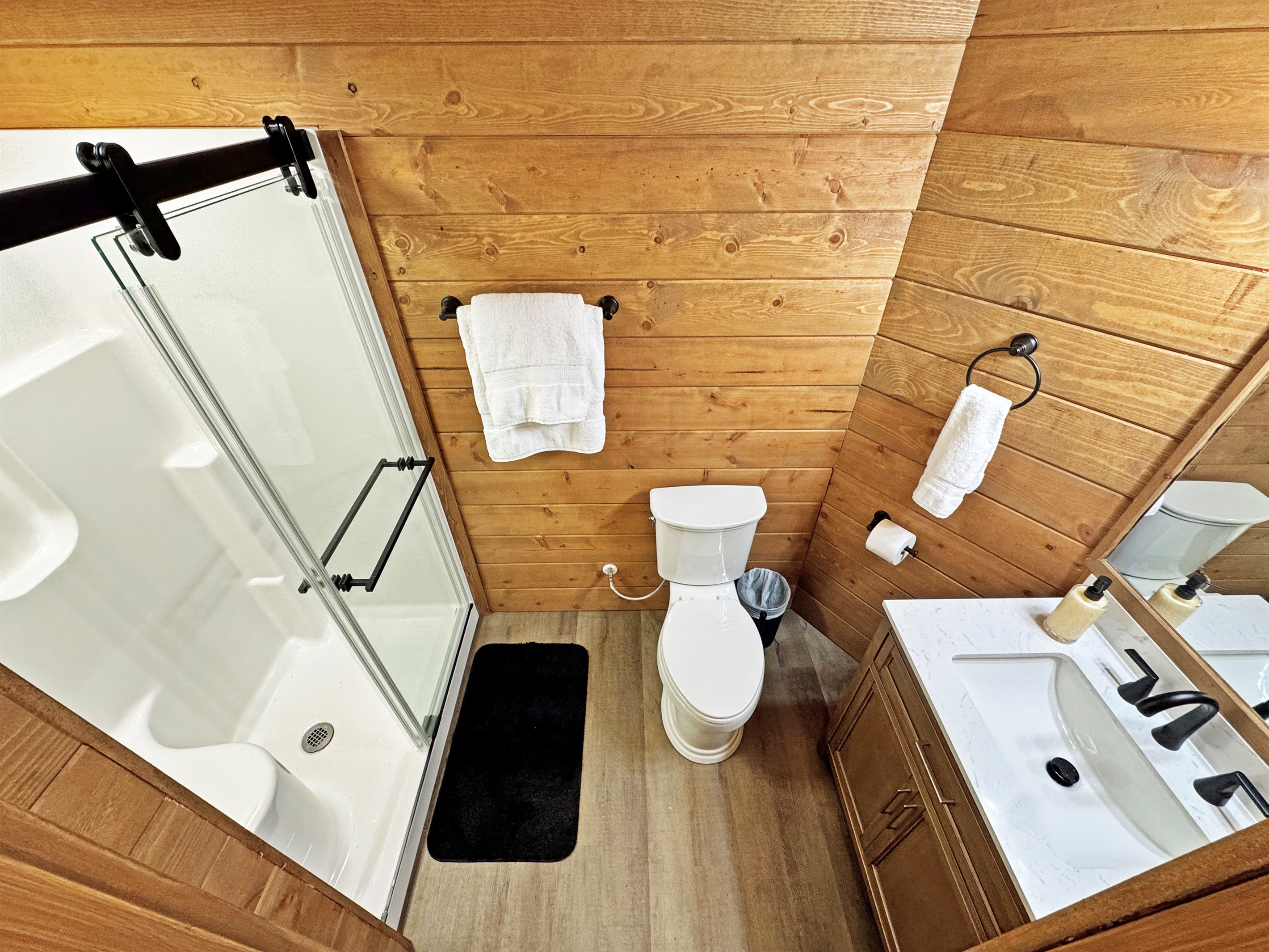 Bathroom Oasis: Enjoy modern elegance with natural wood accents and a refreshing shower experience!