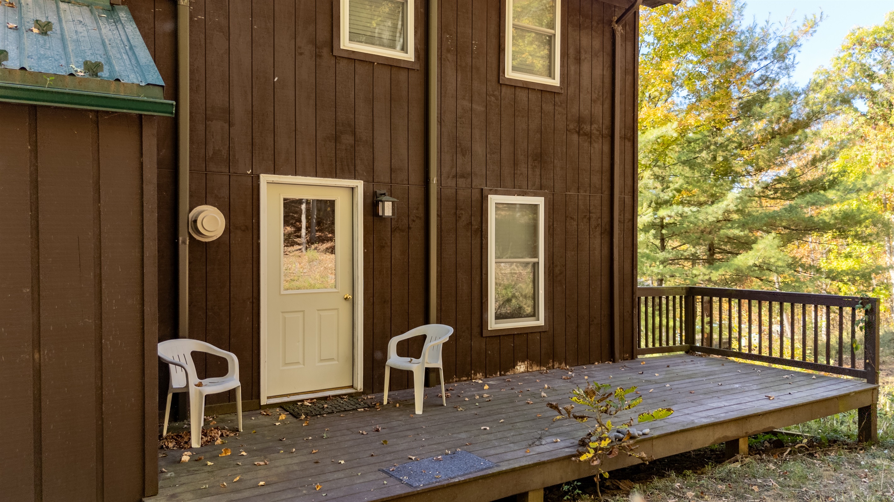 Entry door view plus two chairs on the porch — inviting and relaxed.