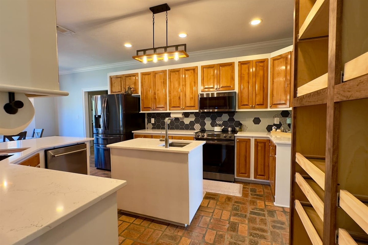 Organized shelving, recessed lighting, and spacious counters make cooking both practical and stylish.