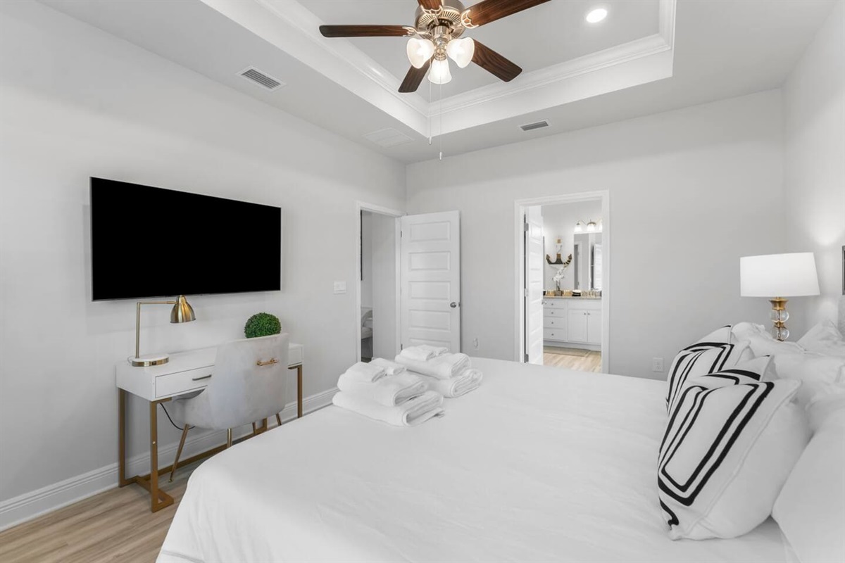 Enjoy comfort and style with a bright bedroom, cozy lamps, and a ceiling fan.