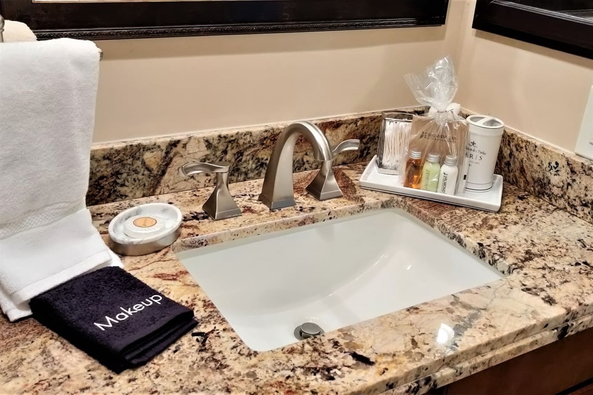 Resort like amenities including shampoo, conditioner, soaps, body lotion, Q-Tips, cotton balls, hair dryer, and makeup remover cloths. 
