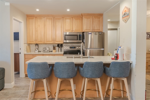 Fully loaded kitchen with seating for four at the counter.
