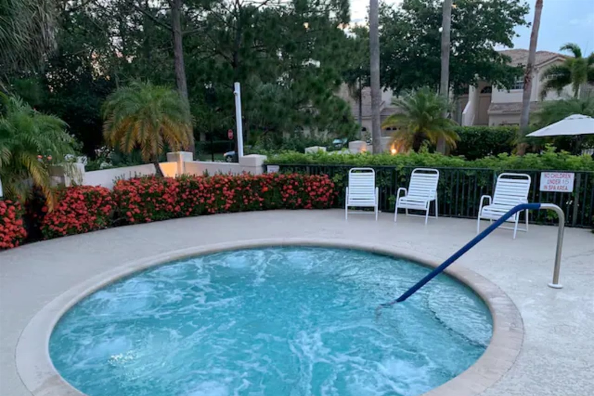 Relaxing community spa area surrounded by lush landscaping, offering the perfect place to unwind after a day in the Florida sun.