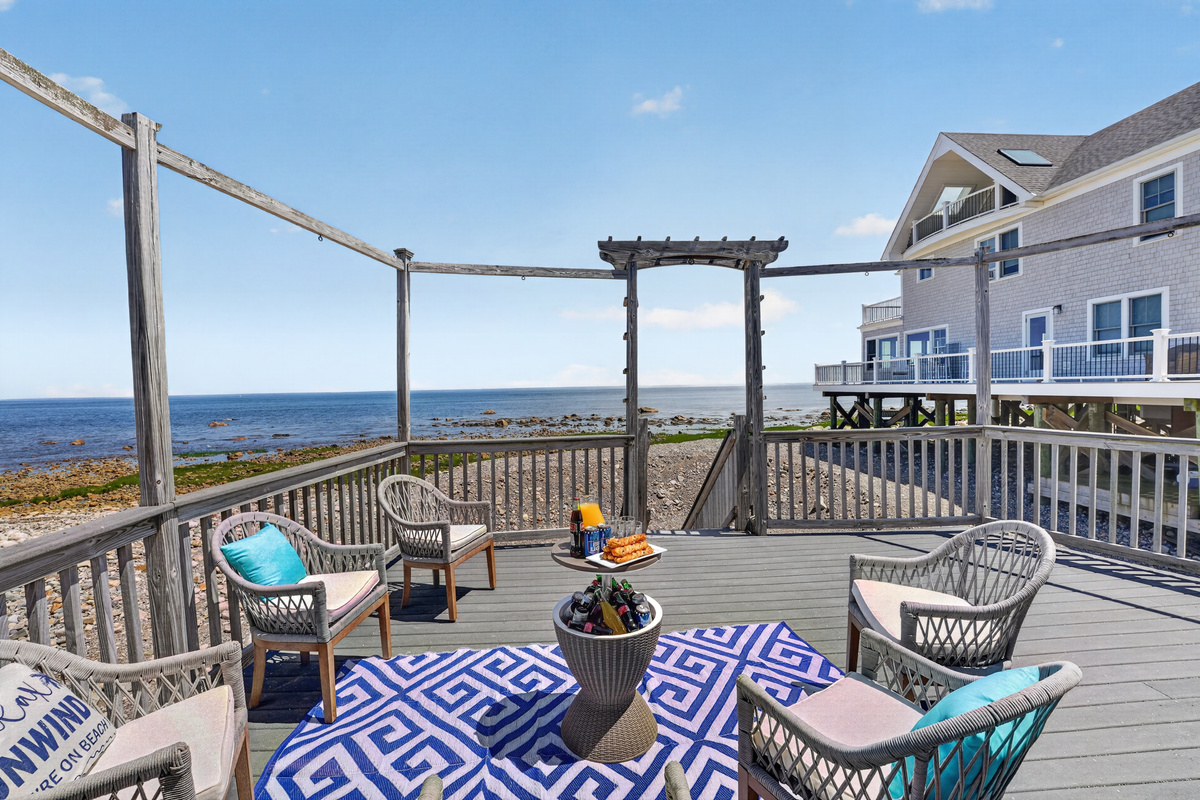 Expansive waterfront deck with comfortable seating—perfect for dining, relaxing, and watching the waves.
