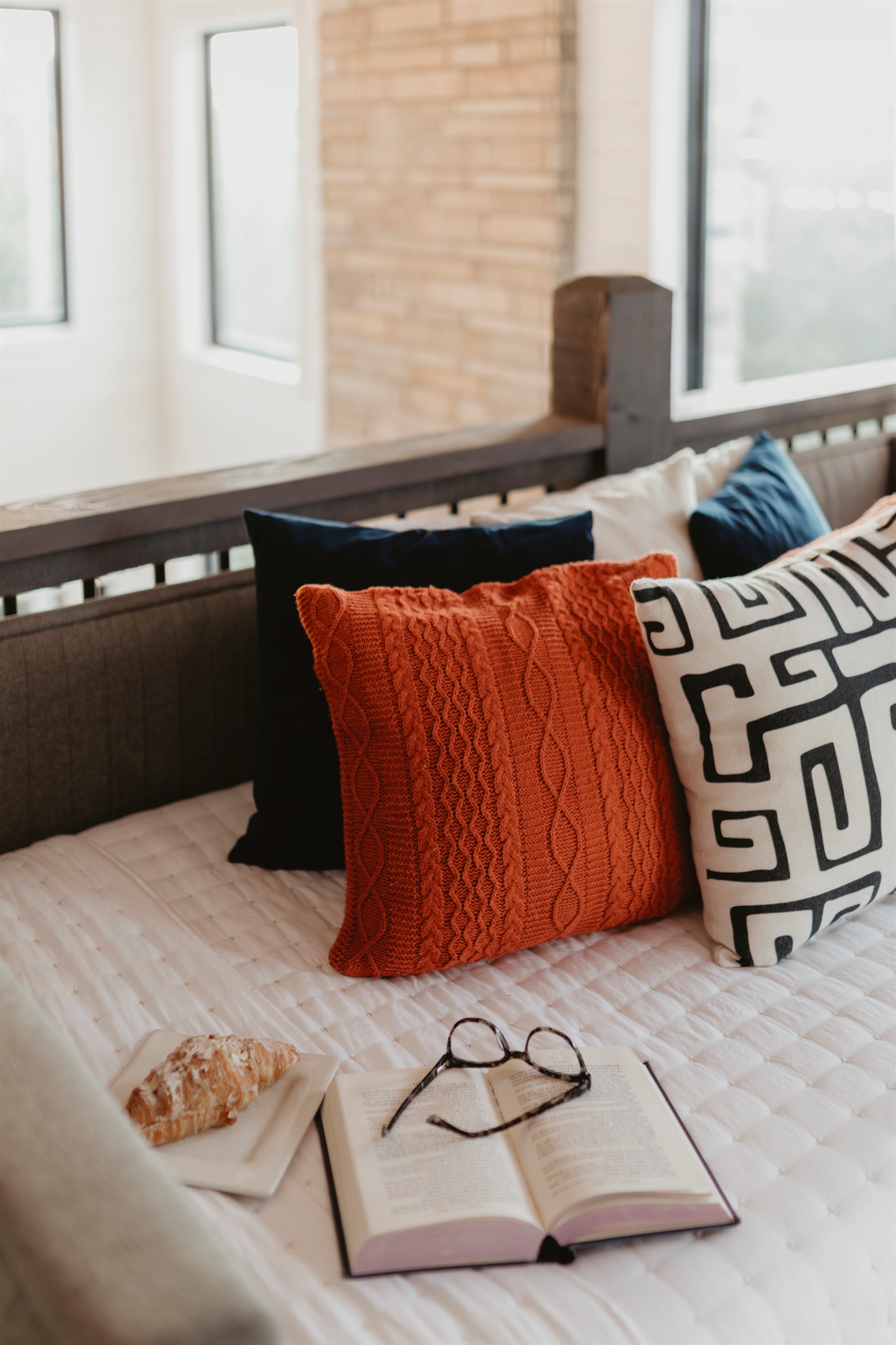 A cozy detail shot with textured pillows and soft linens. Perfect for curling up with a book, a pastry, or just soaking in quiet cabin mornings.