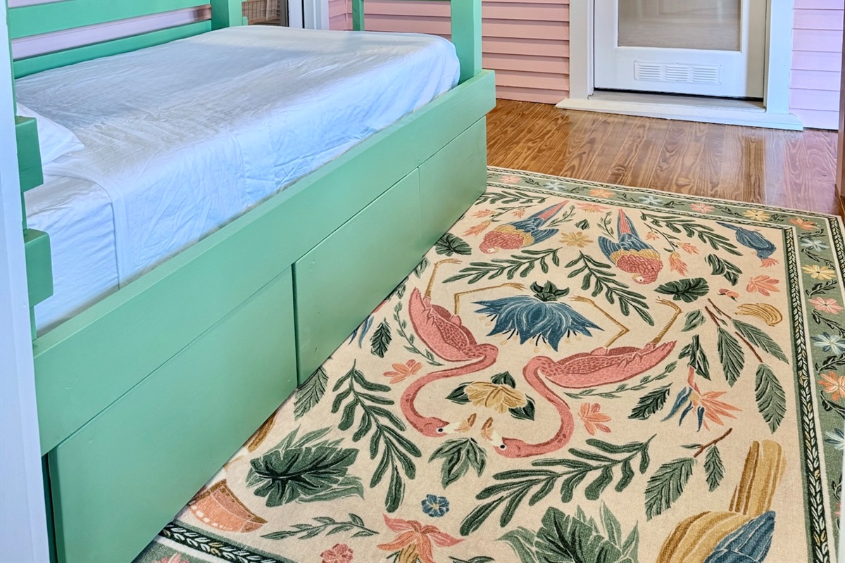 Bright coastal bunk room with built-in twin bunks and a wall-mounted TV—perfect for kids or extra guests.