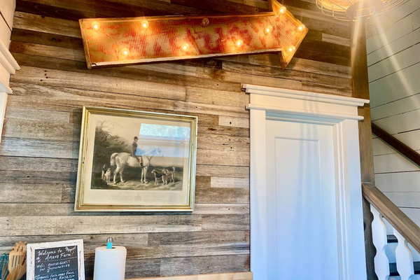 The farm’s old rose garden fencing finds new life on this wall, alongside art from the family collection.  
