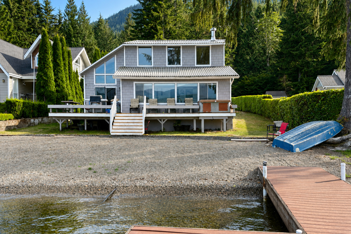 Exterior view of the house overlooking the sandy beach and private dock, with beautiful lake views and easy access to the water.