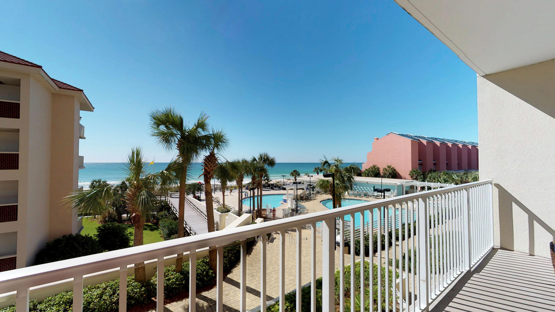 Private balcony overlooking the pools, beach, and Gulf.