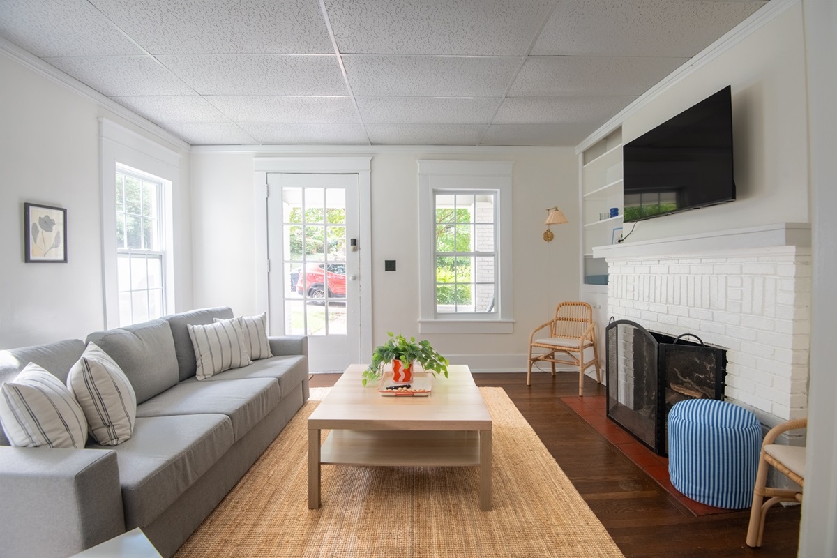 Bright and cozy living room with comfy seating, a smart TV, and plenty of natural light—perfect for relaxing after a day out.