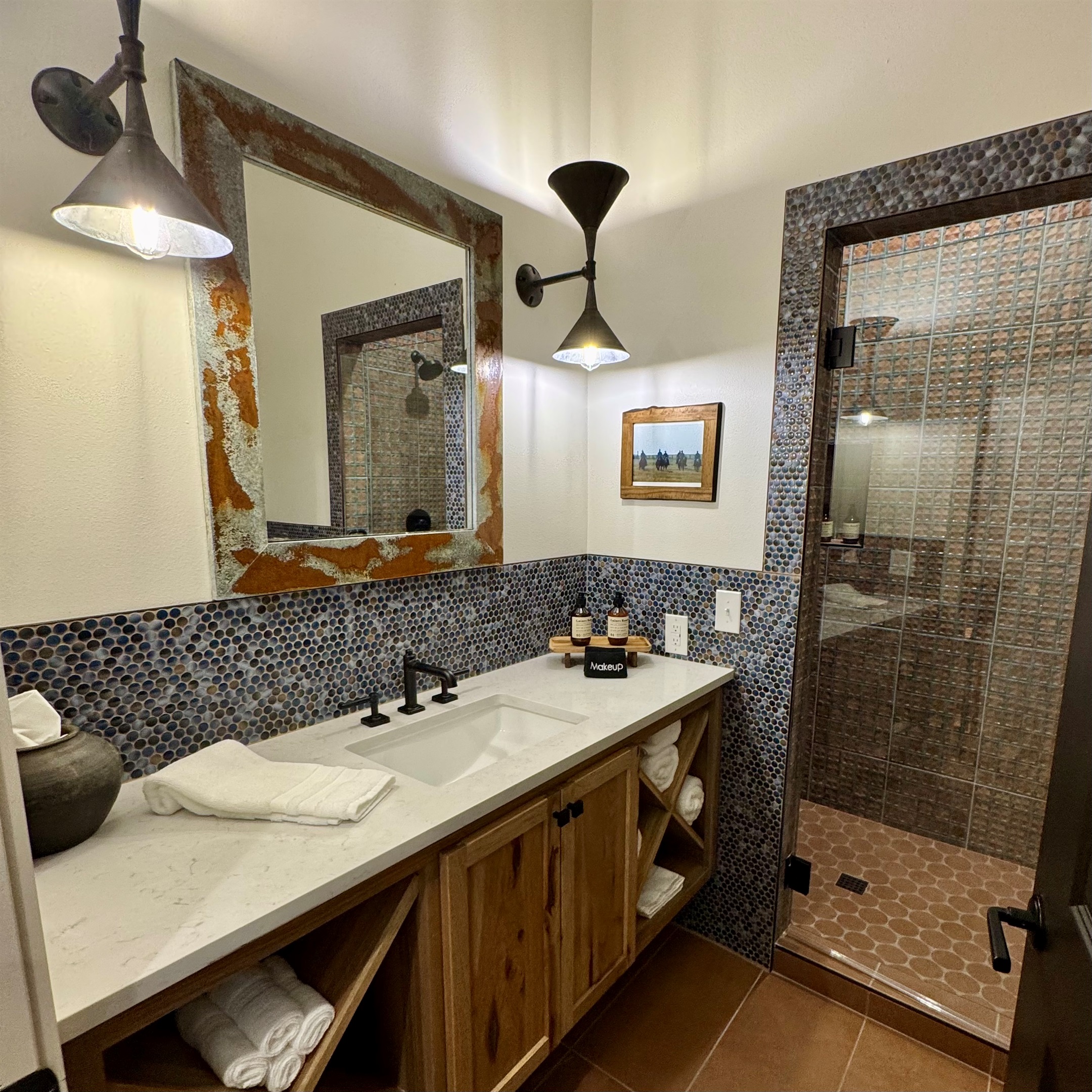 Cutter's Quarters Bathroom #1 wide — walk-in tile shower, designer vanity, and modern Western finishes. One of six private bathrooms across the entire property.