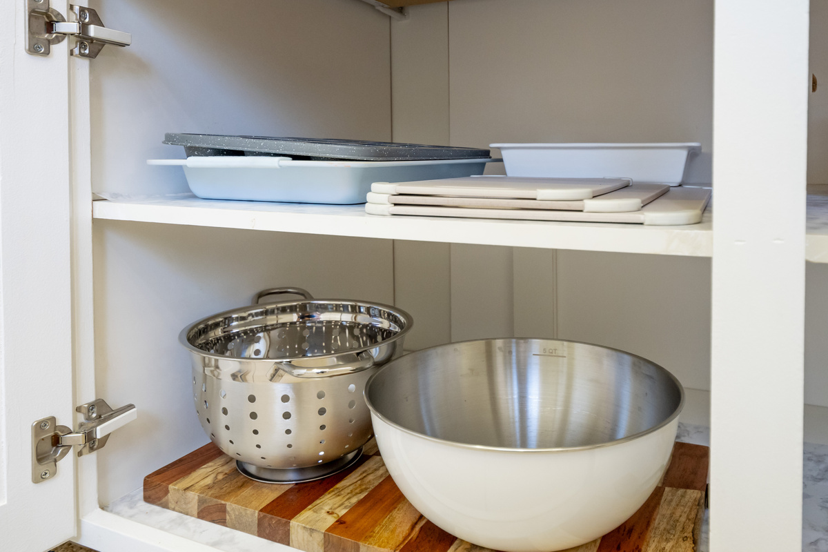 The kitchen is equipped with serving dishes, mixing bowls, and cookware essentials to help you prepare and share your favorite meals.