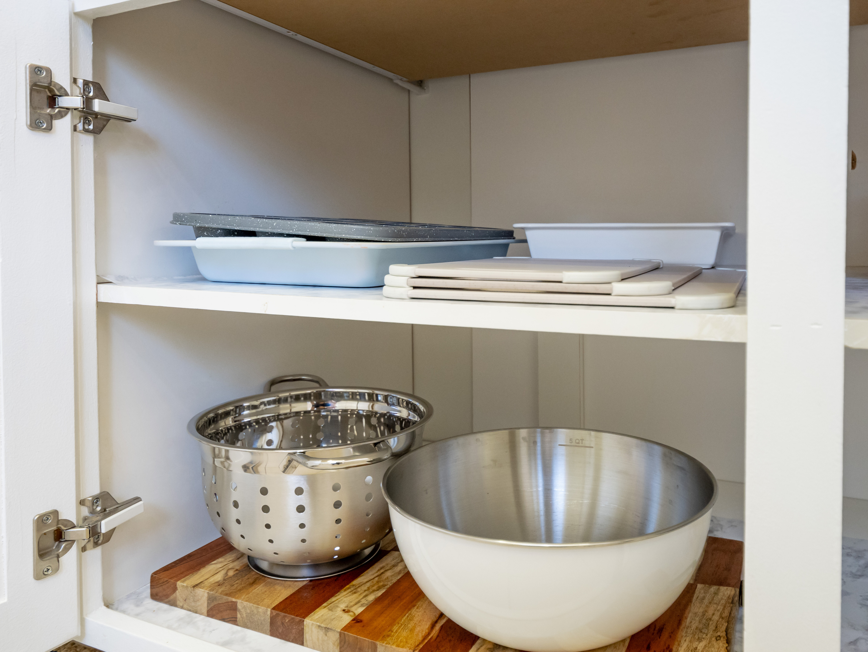 The kitchen is equipped with serving dishes, mixing bowls, and cookware essentials to help you prepare and share your favorite meals.