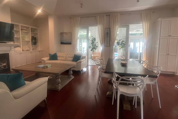 Breezy open living, kitchen, and dining with carefree white leather sofas and easy clean eating.