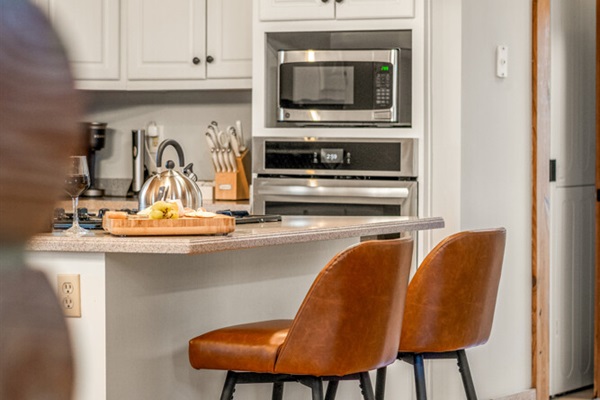 Gather for meals in the dining area with rustic cabin charm, plenty of seating, and natural light pouring in from the windows.