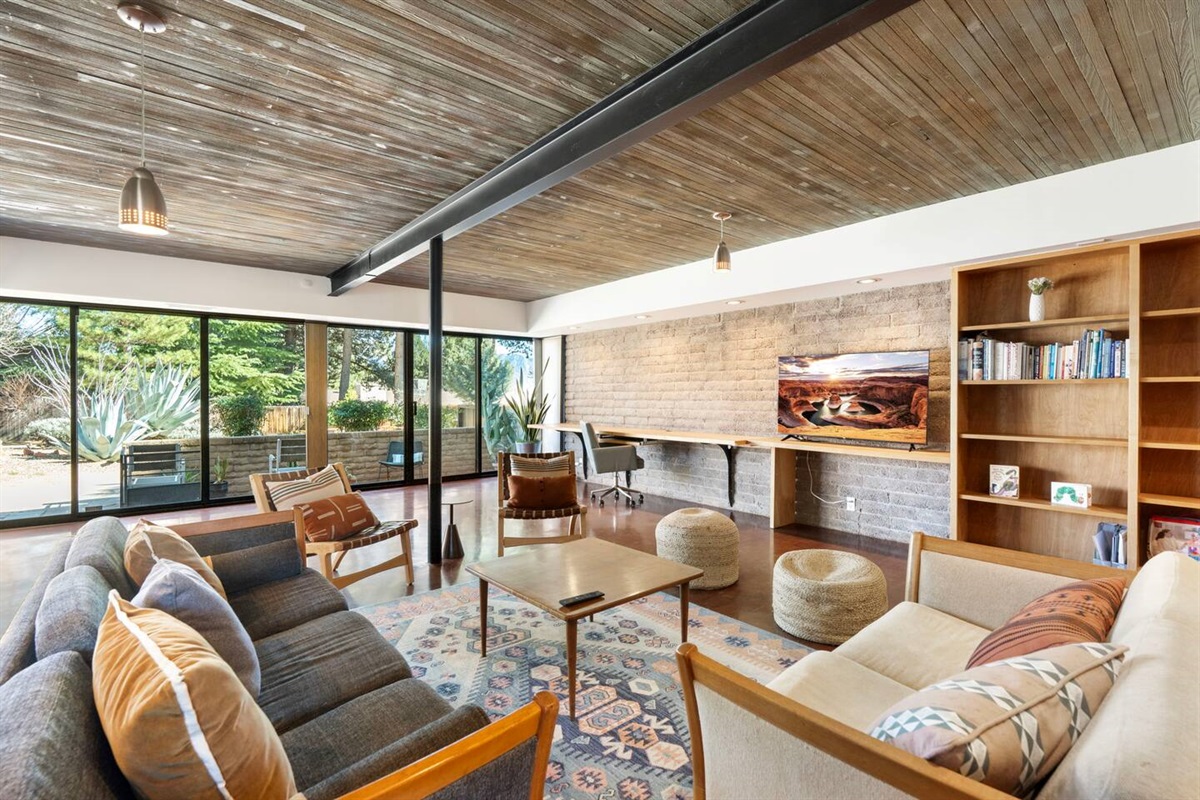 Spacious open living area with warm wood ceilings and inviting mid-century charm.