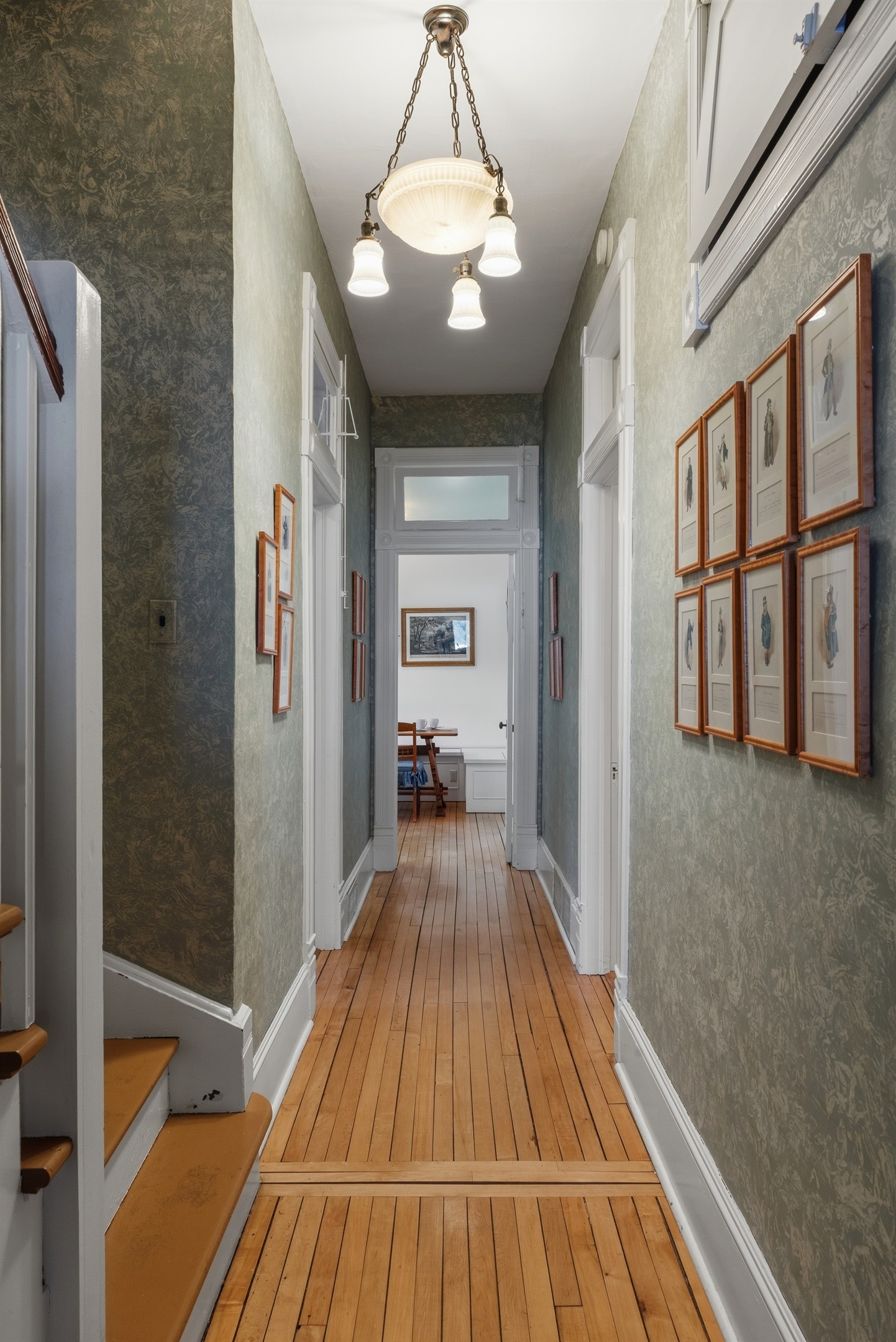 Main floor hallway lined w/ framed artwork & soft lighting
