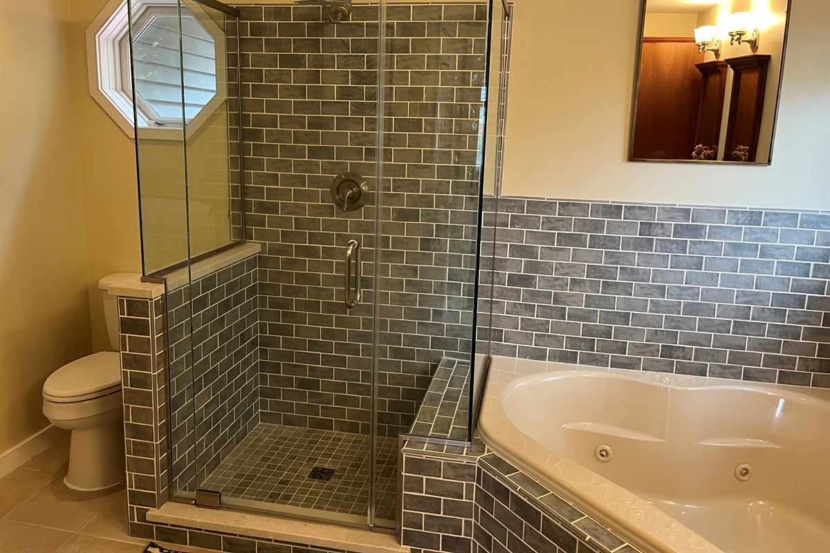 Primary bath with jetted tub and frameless glass shower