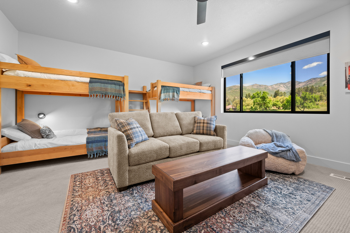 Upstairs family room with bunk beds, seating, and entertainment area.