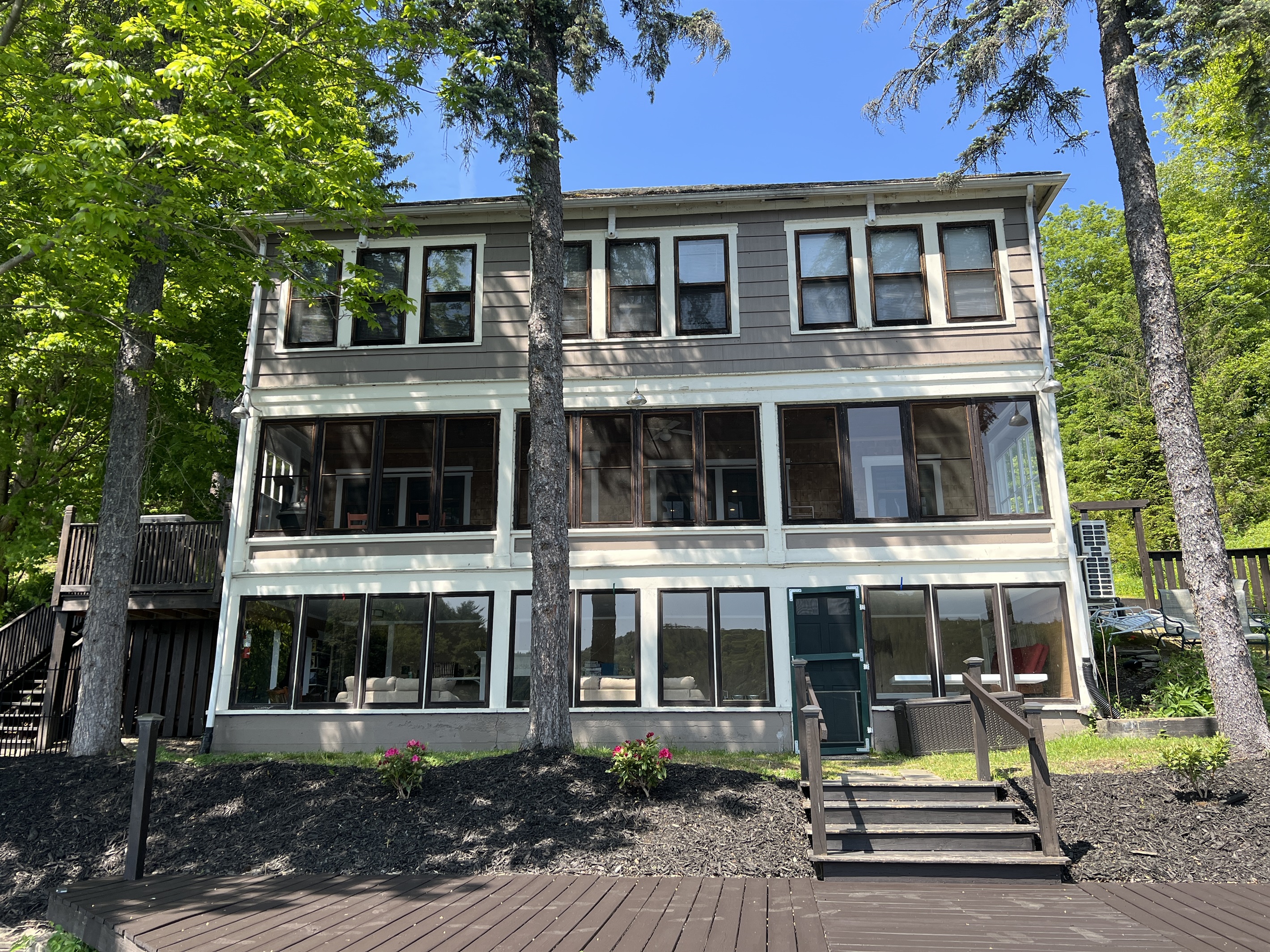 The Adirondack Waterfront Compound main house facing the water, look at all those windows! Enjoy views of the lake from almost every room in the house.