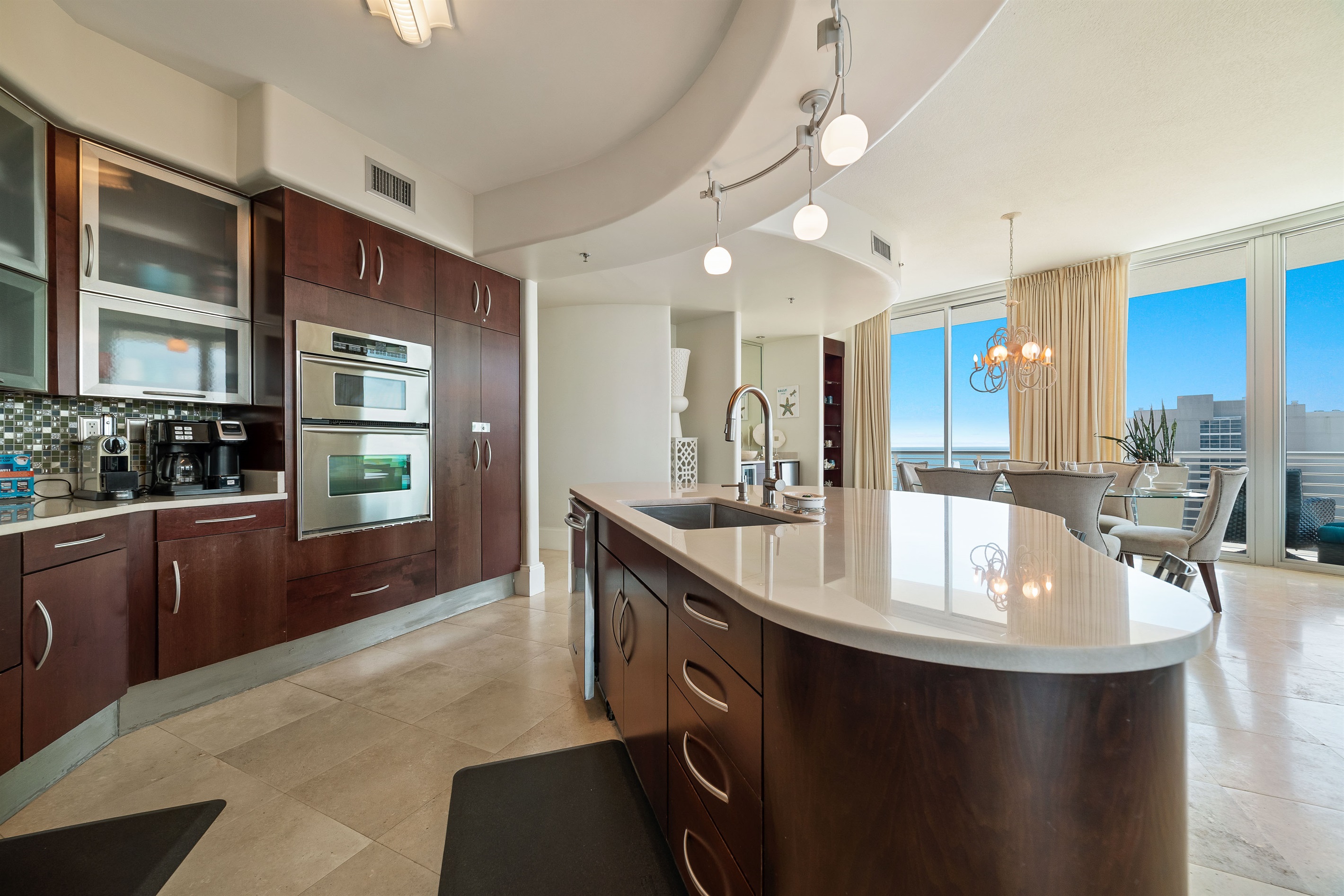 Imagine preparing delicious meals with ease in this well-appointed kitchen, all while staying connected with family and friends in the adjacent living and dining areas. This open-concept design is ideal for a relaxed coastal lifestyle.
