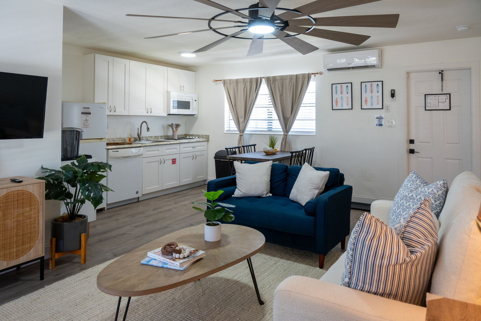 Open living space with full kitchen, dining table, sofas and Smart TV – minutes from the sand