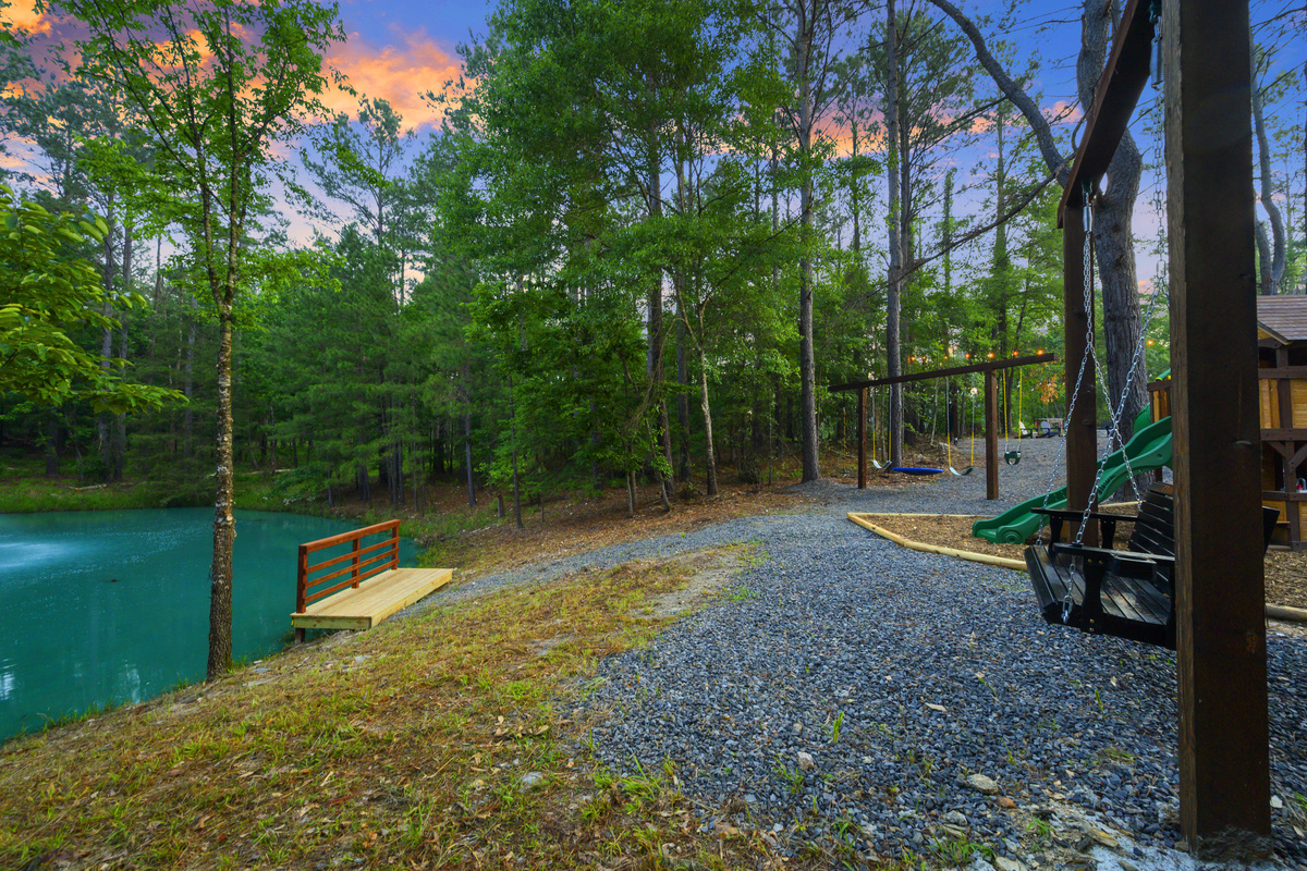 This is why you book a pond cabin. Slow mornings on the swing, kids running down to fish before breakfast, afternoons pool swimming under the pines, and everyone coming back to the water during sunset.